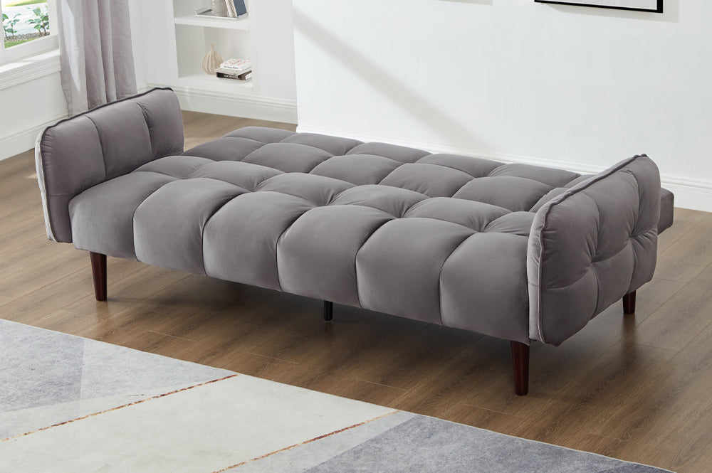 Charcoal grey velvet sofa bed with thick arms and plush tufted back design