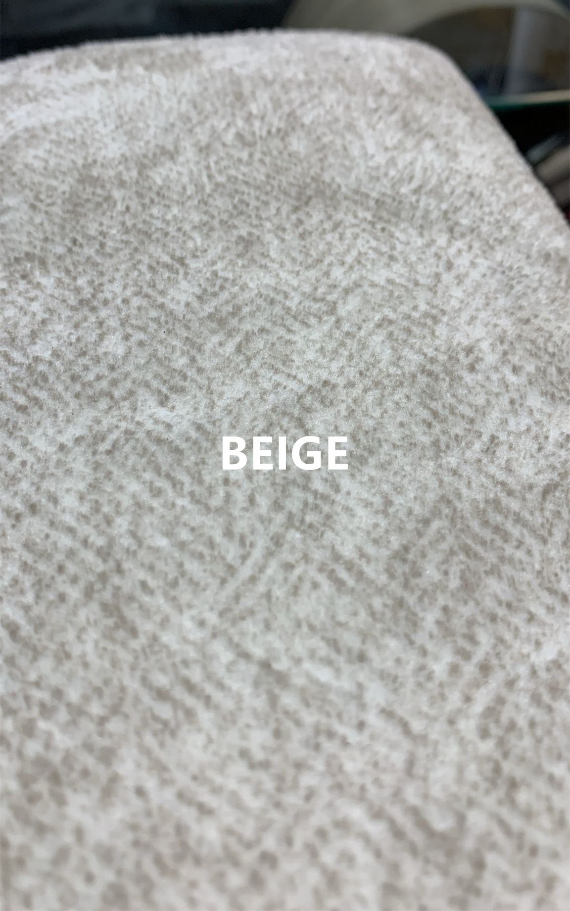 Close-up view of beige chenille fabric upholstery on sofa
